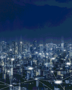 Futuristic city skyline glowing at night, with illuminated skyscrapers linked by bright lines and nodes, suggesting smart-city connectivity.