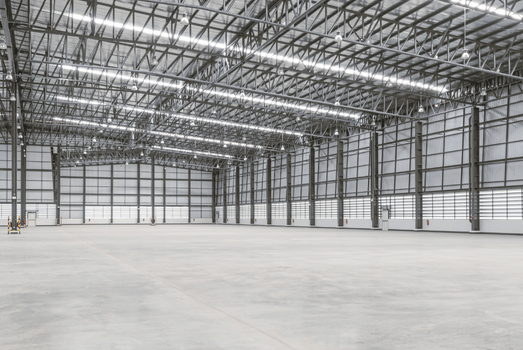 Vast empty industrial warehouse with polished concrete floors, steel trusses, bright strip lighting, and large translucent panel walls, kWh, electrical, LED, energy